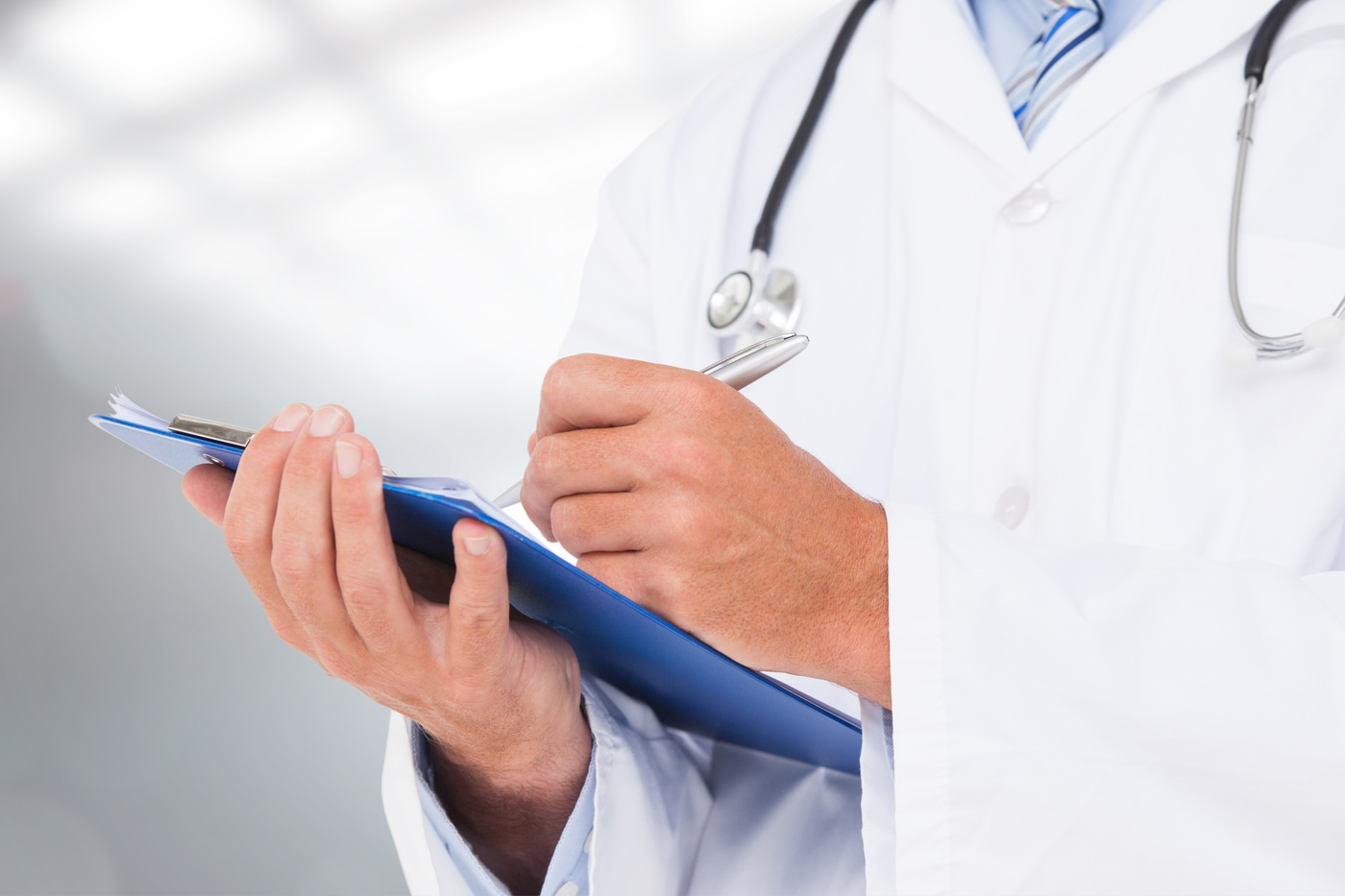 Médico registrando indicaciones en una ficha clínica